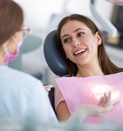 Woman in dental chair talking to dentist