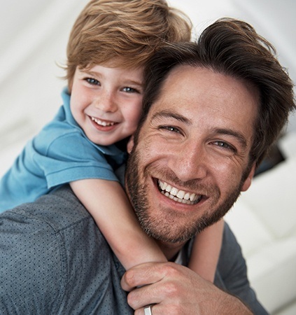 Child and father smiling after dental sealant placement