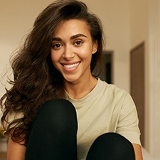 Woman sitting in her apartment and smiling