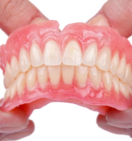 A dentist holding a denture mouth mold 