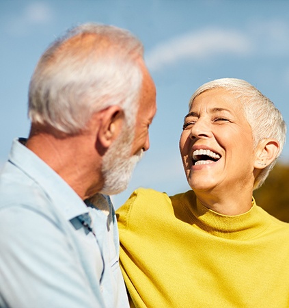 Senior man and woman standing outside and laughing