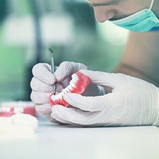 Dentist inspecting dentures in Richmond