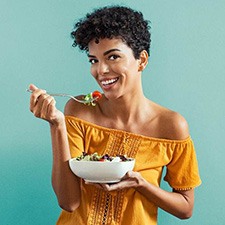 a woman eating healthy to prevent dental emergencies in Richmond