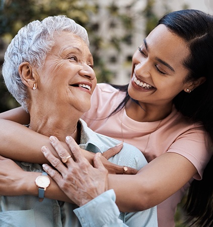 a mother and daughter hugging and smiling each other