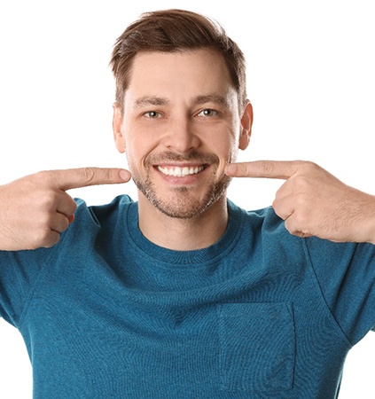 Man with dental implants in Richmond pointing at his smile