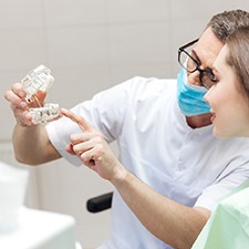 Implant dentist in Richmond showing patient how dental implants work