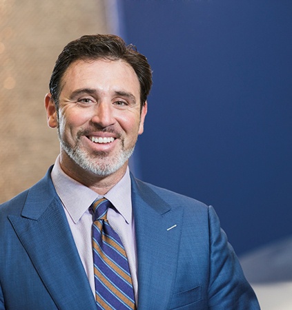 smiling man wearing a dark blue suit