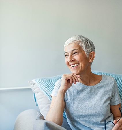 Senior woman sitting on couch and smiling