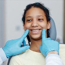 Teen smiling while dentist examines teeth