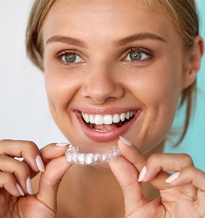 Woman placing Invisalign tray