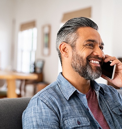 Man smiling while talking on phone