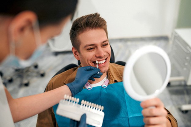 Patient in Tuckahoe smiling in mirror at dentist