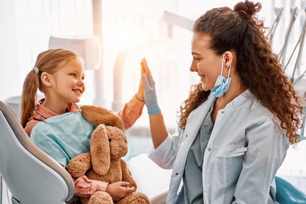 Young patient in Tuckahoe high-fiving dentist