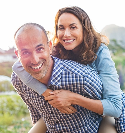 Man and woman sharing smiles repaired with dental crowns