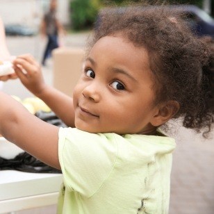 Young child smiling at outdoor community event