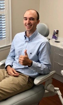 Dental patient in exam chair giving thumbs up