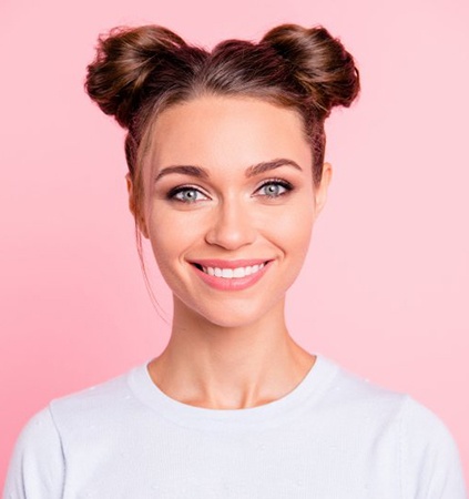 woman smiling against pink background after getting teeth whitening in Richmond 