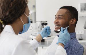 man sitting in dental chair and smiling at dentist in Richmond 