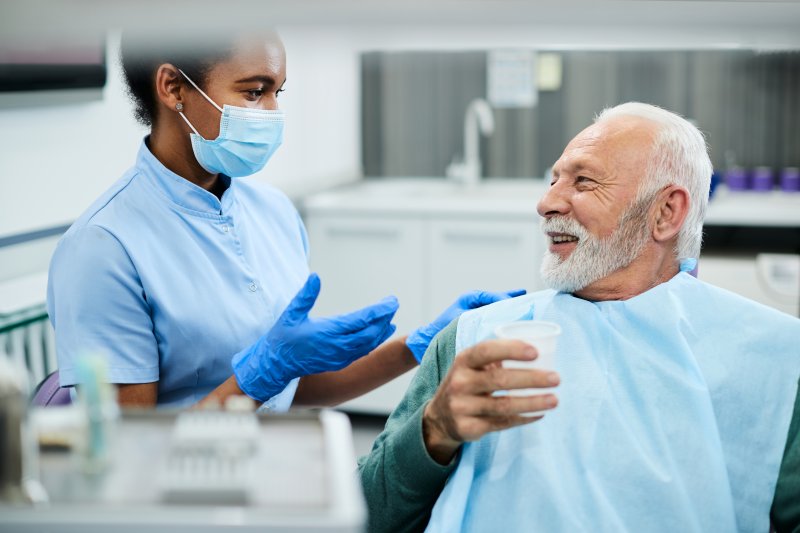 dentist explaining black line around dental crown to patient