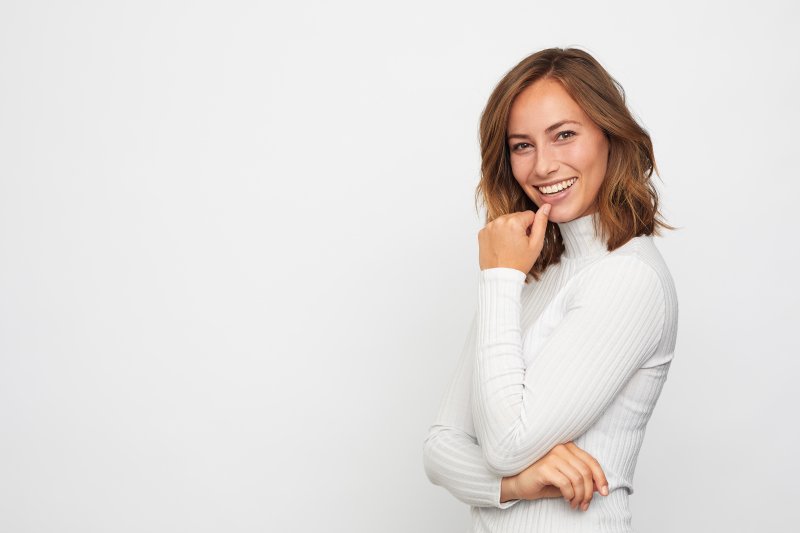 woman smiling and thinking about veneers and Invisalign in Richmond