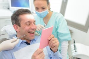 Man smiling after getting his permanent crown placed
